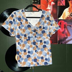Light blue v neck babydoll style blouse, with blue and brown polka dots.